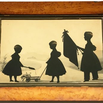 Cut & gilded silhouette of three children in a garden