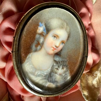 Miniature portrait of a child with a grey tabby kitten