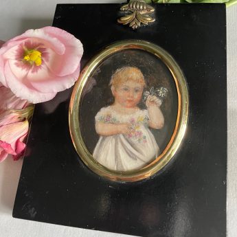 Miniature portrait of a child holding flowers