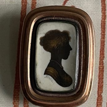 John Field, gilded silhouette of a lady in a brooch setting