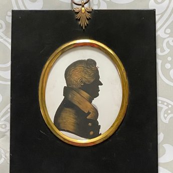 A pair of silhouettes painted on plaster with gilding