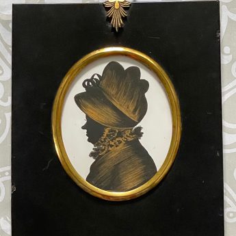 A pair of silhouettes painted on plaster with gilding